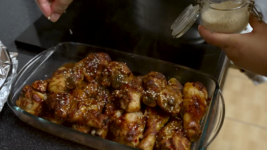 Seeds Being Sprinkled Over freshly cooked chicken meat. Slow Motion Shot