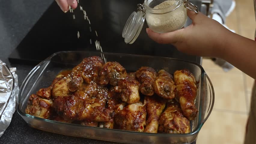 Dried Seeds Being Sprinkled Over freshly cooked chicken meat. Slow Motion Shot