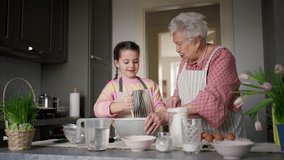 Grandmother with grandaughter preparing traditional easter meals, baking cakes and sweets. Passing down family recipes, custom and stories. - Powered by Shutterstock - Get 15% off with code: PIKWIZARD15