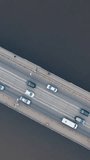 Urban car traffic on the bridge over the river. Shooting with a drone. Vertical video.