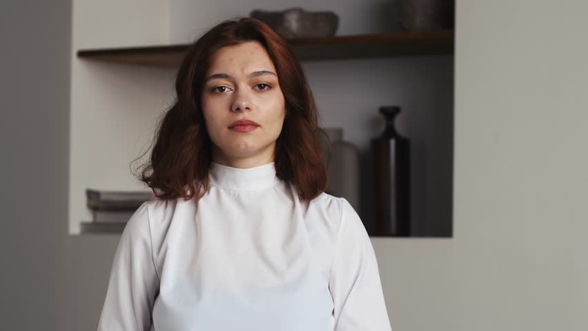 Portrait displeased woman gesturing stop sign with hands at home . Closeup young model saying no on office background. Serious girl showing negative gesture at camera in slow motion. Displeased lady
