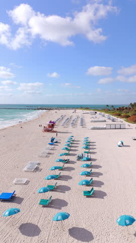 2024 slow motion vertical aerial Miami Beach umbrellas and lifeguard tower
