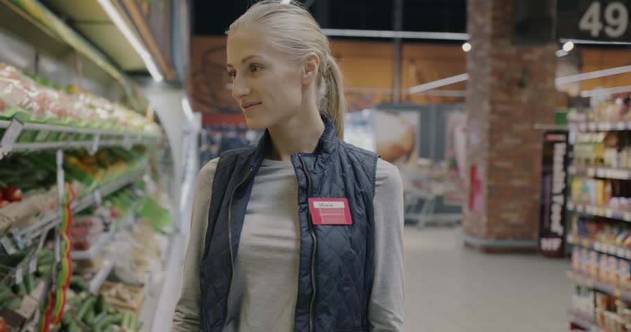 Slow motion portrait of young woman shop assistant standing in supermarket smiling looking at camera. Retail store worker and greengrocer's concept. Royalty-Free Stock Footage #3463282503