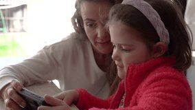 Digital Inclusion: Mother and Autistic Daughter Engaged in Smartphone Interaction - Powered by Shutterstock - Get 15% off with code: PIKWIZARD15