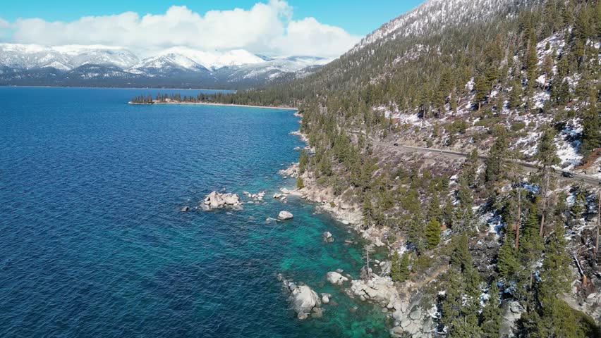 Aerial view of Lake Tahoe rocky shoreline with mountains in the distance