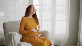 Happy pregnant woman stroking belly. Positive young female enjoying waiting baby at home near window indoors. Future mom relax at home. Happy pregnancy in family, healthy motherhood love concept. - Powered by Shutterstock - Get 15% off with code: PIKWIZARD15