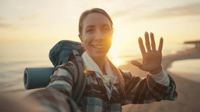Woman tourist makes a video of sea sunset. Female hiker blogger with touristic backpack recording video of nature on smartphone on vacations. Travel tourism blog hiking camping wanderlust concept.