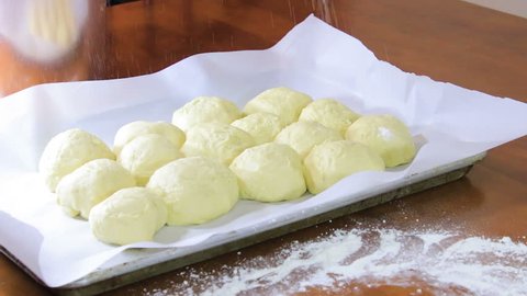 Sprinkling flour over bread rolls