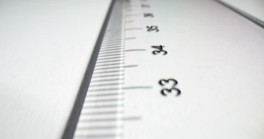 Transparent ruler displays easily readable and legible centimeter digits. Well-defined numeric markings line edge of transparent ruler slow motion