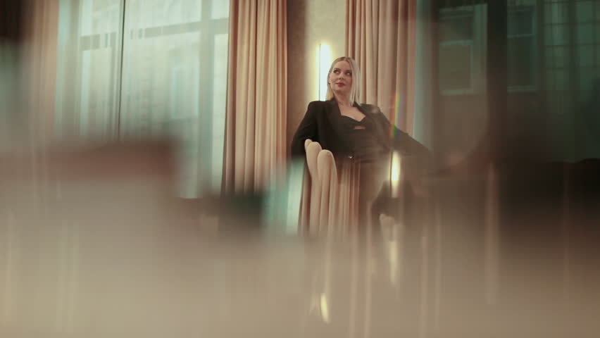 Beautiful, artistic shots of a business woman, a blonde in a black suit. Concept: new business, communication, white, banker, manager.