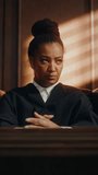 Cinematic Court of Law Trial: Vertical Portrait of Impartial Thoughtful Female Judge Looking at Camera. Wise, Incorruptible, Fair Justice Doing Her Job Professionally, Sentencing Criminals