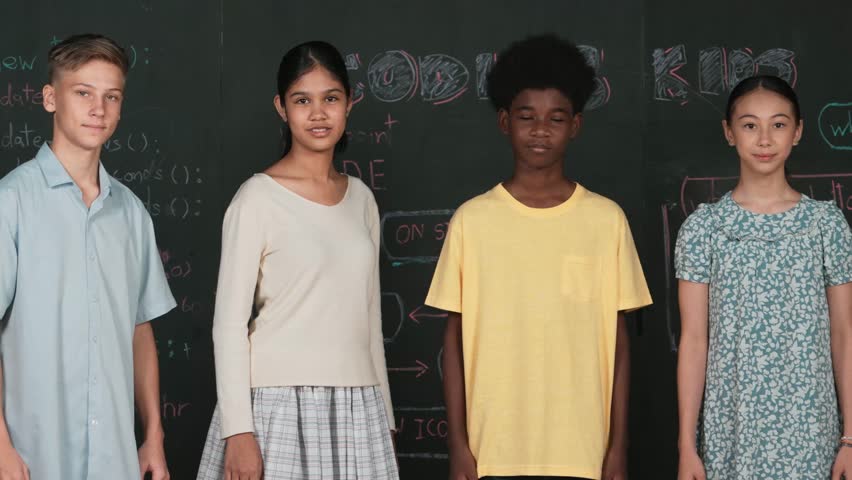 Multicultural people pose at camera while standing with confident. Diverse high school children crossing arm or posing to camera at blackboard with prompt or coding plan at STEM class. Edification