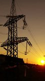 Industrial factory and electricity pylons at sunset. Silhouettes of high voltage power lines against the setting sun. Industrial minimalist landscape. Vertical video