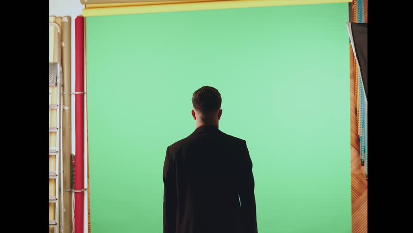 A man on the background of a chromakey picks up a phone, a man with a raised phone on the background of a chromakey