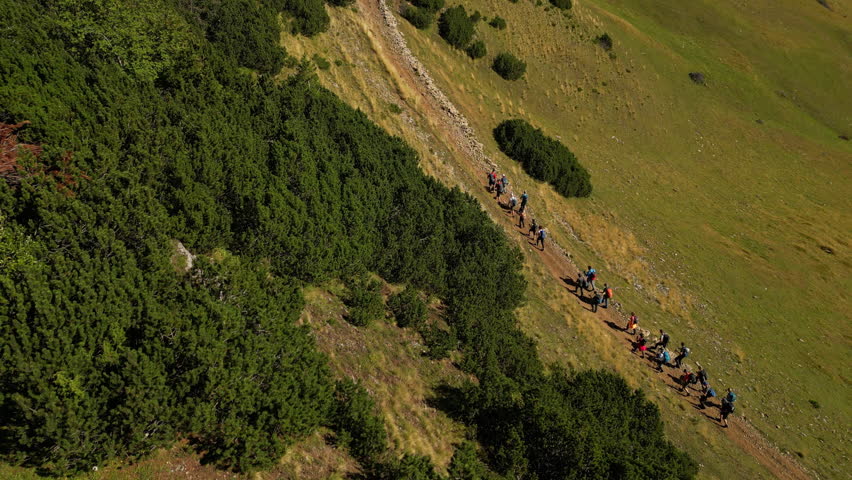Aerial Shot of a Group of Backpackers Hiking on a Trail Path. Concept of healthy lifestyle, vacation activity, recreational pursuit, backpacking, trekking, hobby