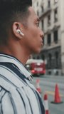VERTICAL VIDEO: Close up, young man crossing the road