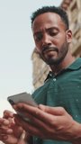 VERTICAL VIDEO, Young man uses map app on his phone