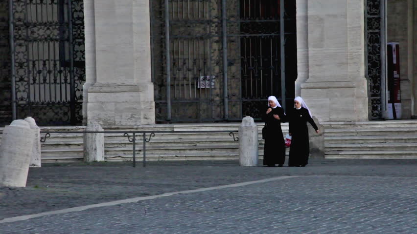 ROME - CIRCA MAY 2012: Two nuns cross Piazza San Giovanni
