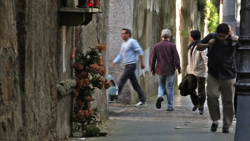 ROME - CIRCA MAY 2012: Pedestrians walk down a street in the afternoon