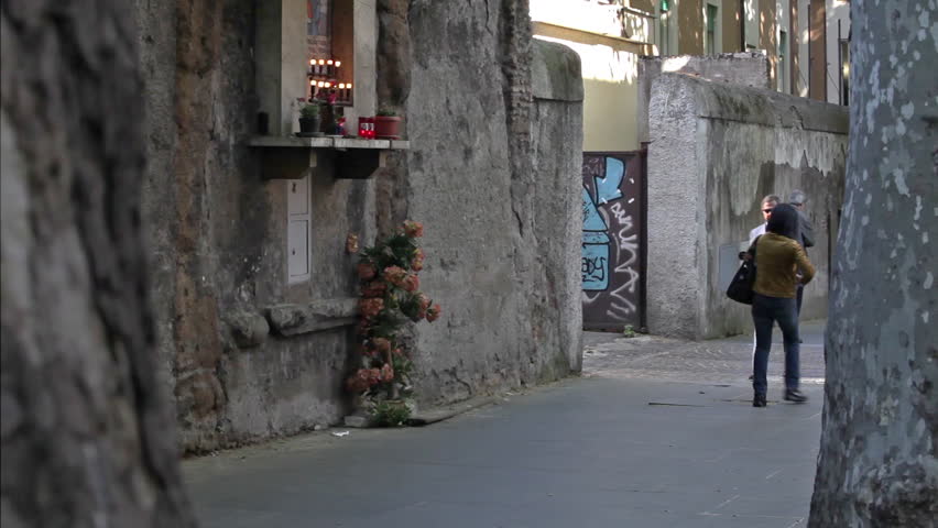 ROME - CIRCA MAY 2012: A sunglasses-wearing man walks down a sidewalk