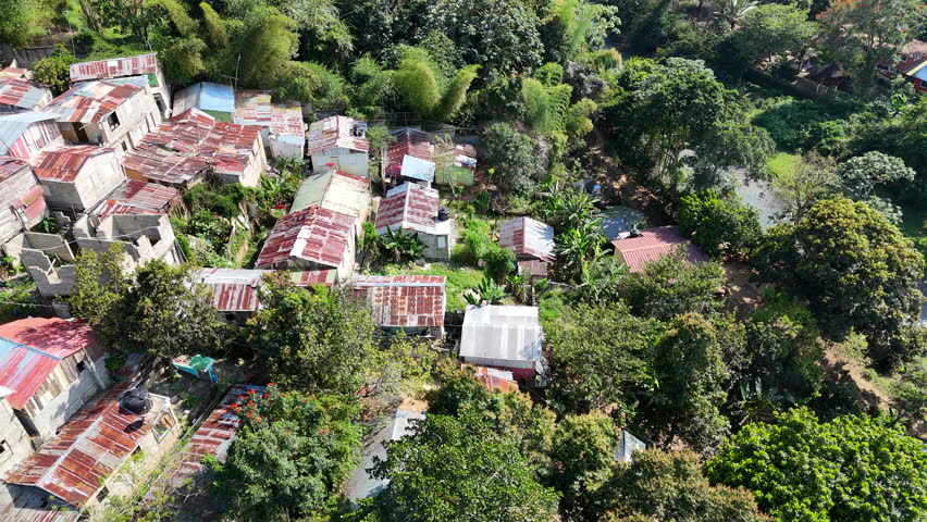 Aerial birds eye shot of poor Neighborhood with rusty roof in tropical suburb of Dominican Republic. Sunny day with palm trees on Hispaniola island. Royalty-Free Stock Footage #3464096133