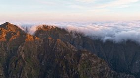 A drone hyperlapse shot at sunrise at Pico de Arieiro in island of Madeira showing the movement of clouds over the mountain