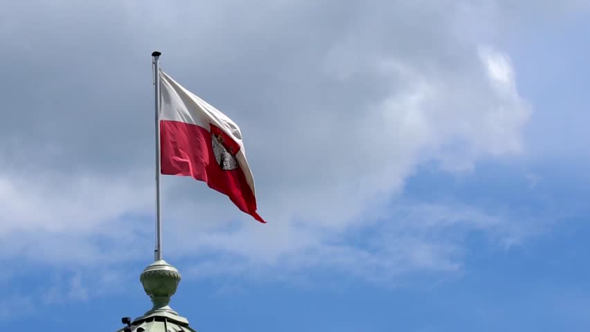 The Salzburg flag waves against a backdrop of shifting clouds.