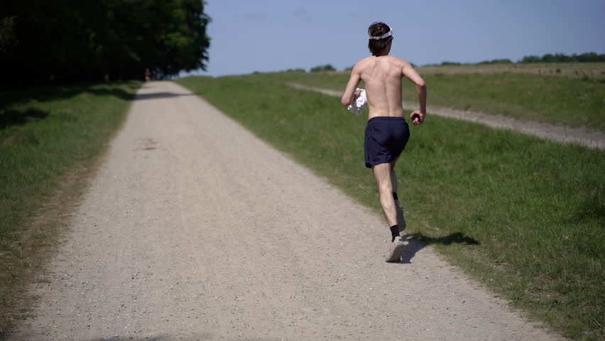 Running Man. A bare-chested man runs along a green meadow.