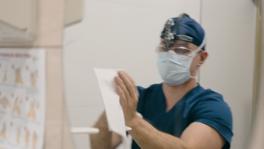Surgeon man doctor washing hands in hospital male medic disinfect palms covid-19 health care protection medical sanitary hand disinfection wipe palms with napkin sterile clean arms sanitizer medicine