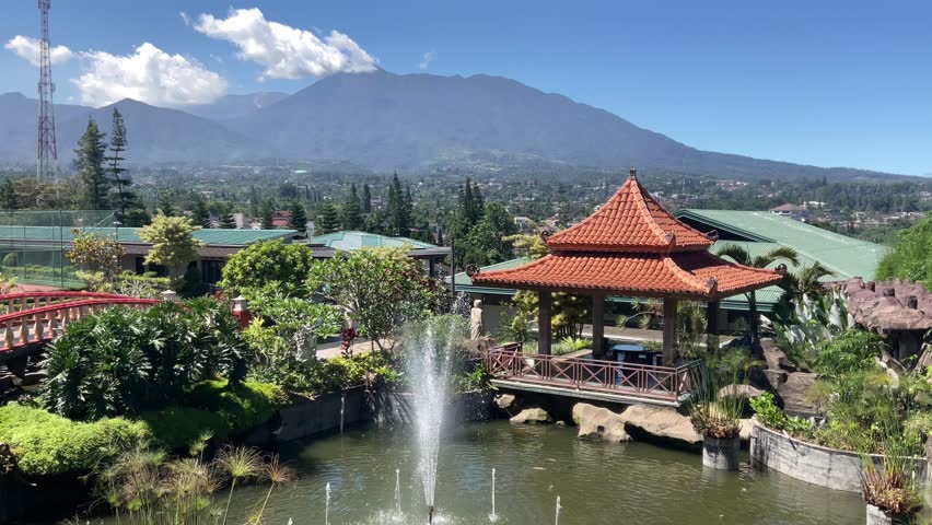 Spectacular fountain splashes in the fish pond of a famous villa garden in Bogor Indonesia with a beautiful mountain background