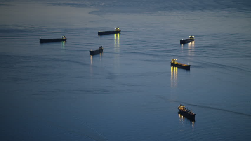 Aerial evening view container ships with illuminated lights anchored offshore English Bay Burrard Inlet Vancouver British Columbia Canada RED WEAPON