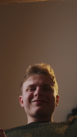 Vertical video. Close-up inside of carton box bottom view, young blonde man opens parcel looks at delivered goods excited, smiling feels satisfied