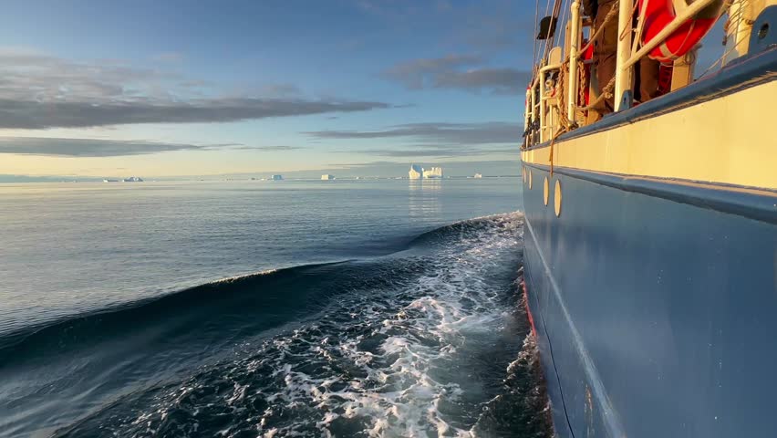 The ship is cruising between the icebergs in Hall Bredning. Scoresbysund, Greenland.