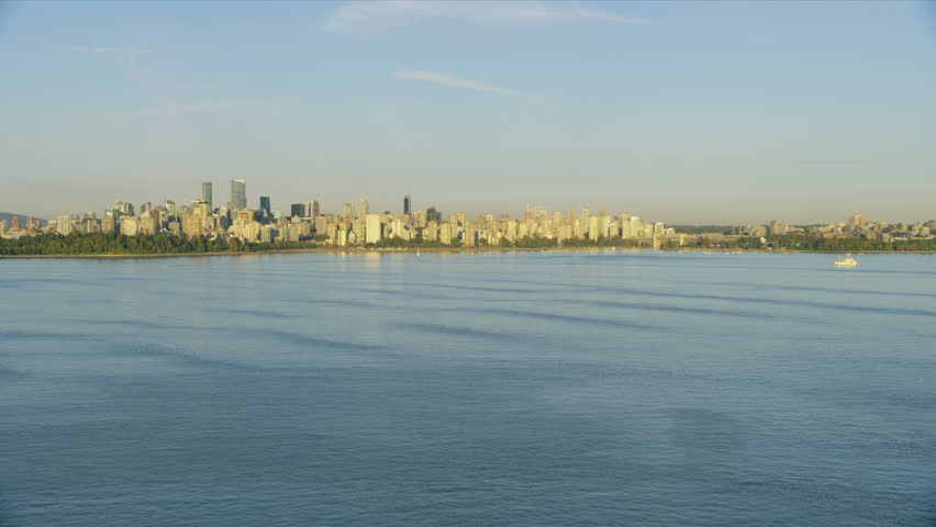 Aerial sunset view across tranquil ocean of English Bay towards skyline of Vancouver city skyscrapers British Columbia Canada RED WEAPON