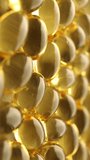 Omega 3 gold fish oil capsules, rotation background, macro. Vertical video.