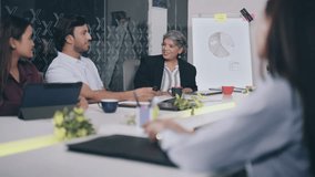 Indian Older professional boss female manager diverse young colleagues sitting on chair do meeting indoor office boardroom. Business executive worker team discuss project new plan idea at workplace - Powered by Shutterstock - Get 15% off with code: PIKWIZARD15