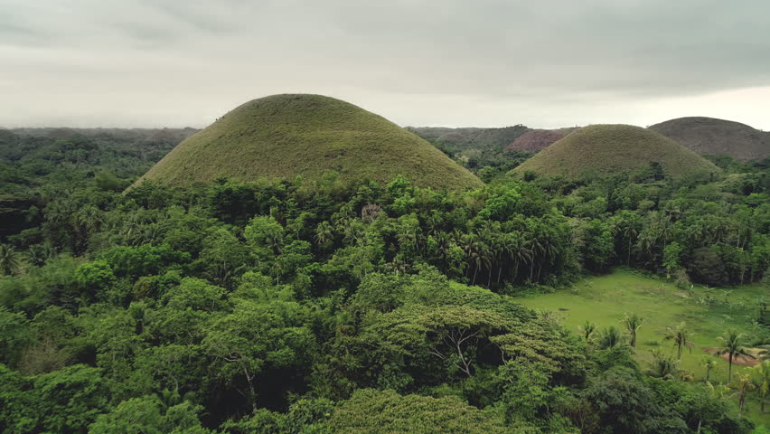 Aerial view Chocolate Hills, Philippines, Visayas, Bohol Island. Charming of lush greenness mounts peaks and hillside trees with abundant leaves. Magnificent attractions Footage shot in 4K, UHD Royalty-Free Stock Footage #3464389205