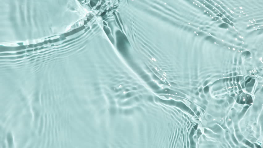 Pure water with reflections sunlight in slow motion. Water surface texture top view. Sun and shadows. Motion clean swimming pool ripples and wave. 