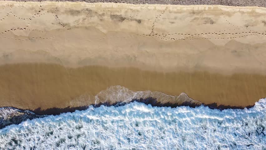 Waves break onto golden sandy beach during sunset in Baja California Sur, Mexico