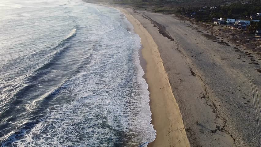 Baja California Sur Mexican beach with waves breaking on Pacific Ocean shoreline during sunset