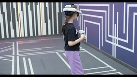 Slow Motion HD Video. Schoolgirls play an online video game using innovative technology in virtual reality glasses and a remote control in the game room.