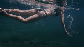 Woman in bikini diving and swimming underwater in the deep blue sea. Girl swimming in ocean paradise. - Powered by Shutterstock - Get 15% off with code: PIKWIZARD15