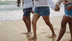 Diverse friends hold hands at shore, strolling sandy beach by waves. LGBTQ group enjoys coastal walk, inclusive vacation scene. Body positivity, freedom in summer, casual attire. - Powered by Shutterstock - Get 15% off with code: PIKWIZARD15