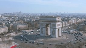 Cars driving around Triumphal arch or Arc de Triomphe in Paris town center, France. Aerial drone view and sky for copy space