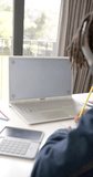 Vertical video of african american boy using laptop with copy space on screen at home, slow motion. Childhood, communication, education, learning and domestic life, unaltered.