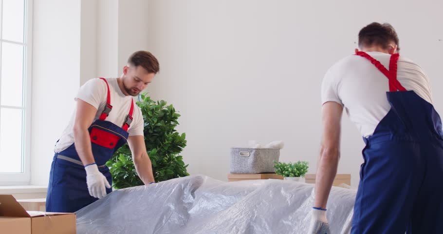 Two sturdy movers transport boxes of belongings into new house. Two movers symbolizing beginning of relocation fresh chapter in life Two movers working carrying new beginnings of relocation Royalty-Free Stock Footage #3464503773