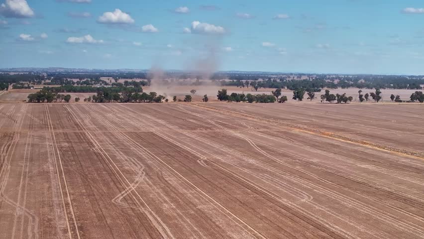 Dust trails over freshly harvested fields in the rural Yarrawonga landscape in Victoria Australia