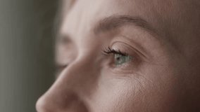 A close-up depicts part of a womans face, highlighting her eye, eyelashes, and the texture of her skin. Her gaze seems reflective and introspective, capturing a moment of thought or observation - Powered by Shutterstock - Get 15% off with code: PIKWIZARD15