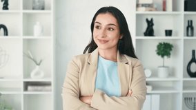 Female video portrait. Confident successful young indian or arabian business woman, ceo, hr manager, dressed in elegant suit, stand in modern office space with arms crossed, friendly smiling at camera
