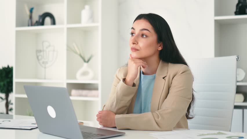 Pensive beautiful successful dreamy arabian or indian business woman, company ceo, corporate lawyer, sitting at desk in the modern creative office looking away and thinking about something Royalty-Free Stock Footage #3464544541